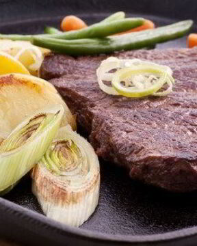 Маринованные говяжьи стейки с жареным зеленым луком